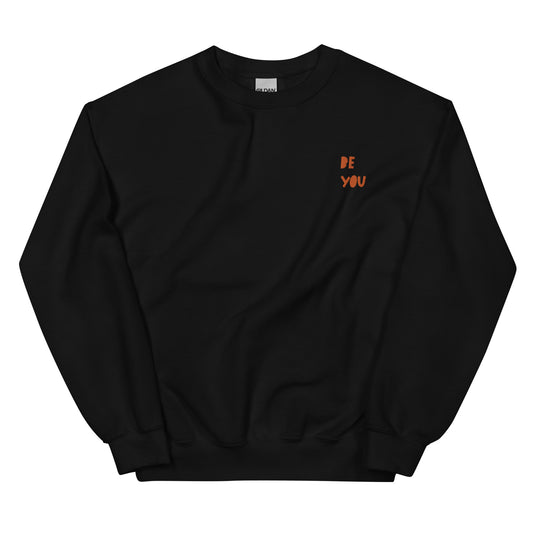 Black unisex sweatshirt with 'Be You' printed in rust-colored text on the upper left chest